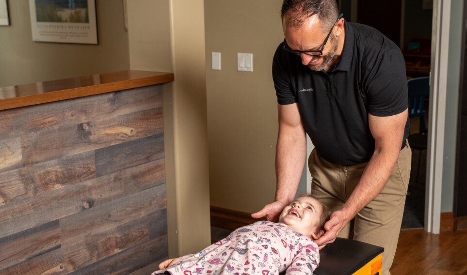 Doctor adjust little girl on table