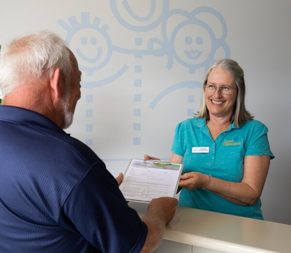 Receptionist handing forms to a patient