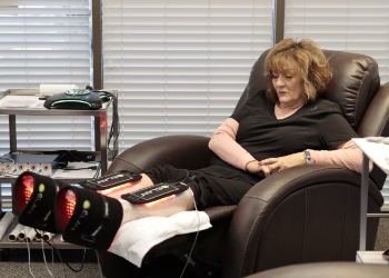 A woman receiving neuropathy while sitting on a recliner.