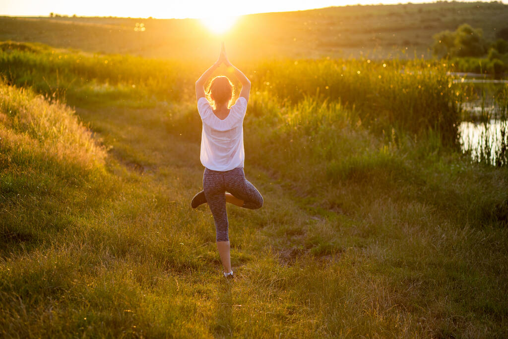 woman in a yoga pose at sunset by lakeside mindfulness and menta