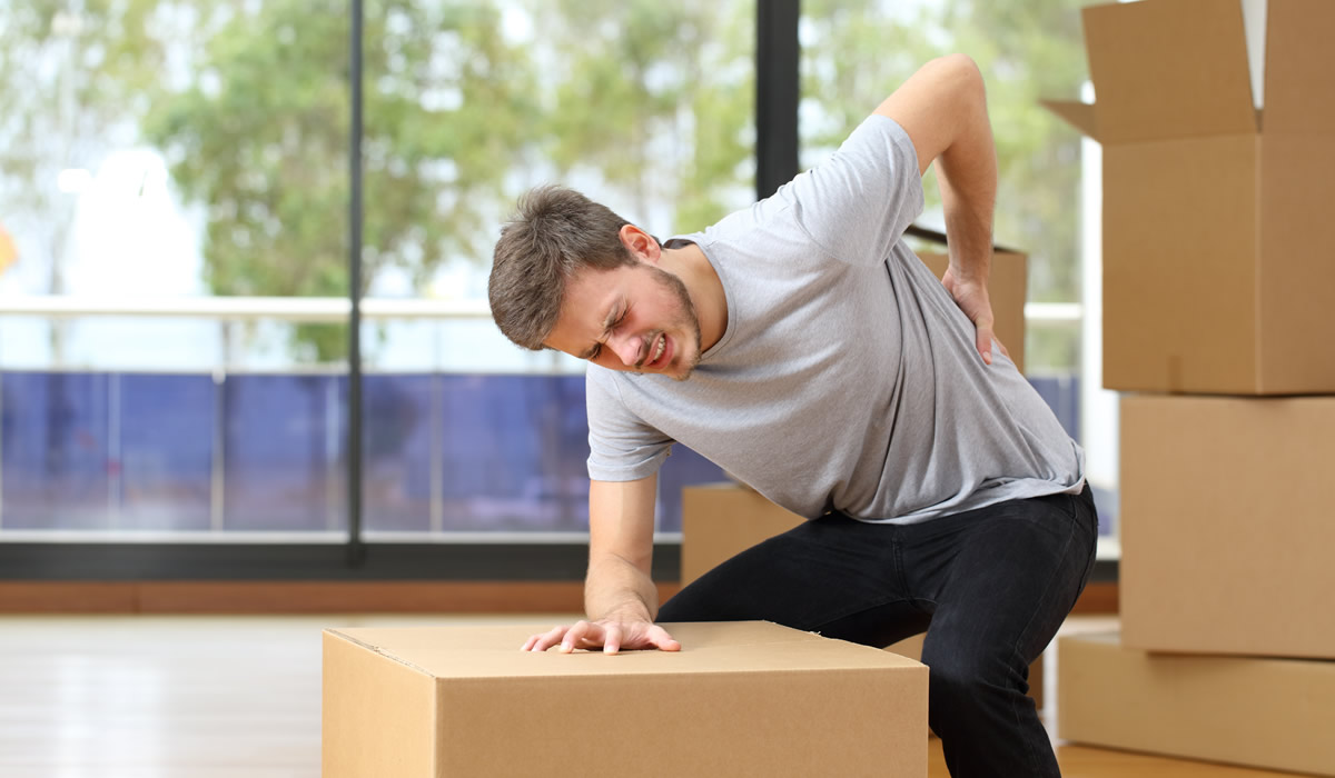 man moving boxes with low back pain