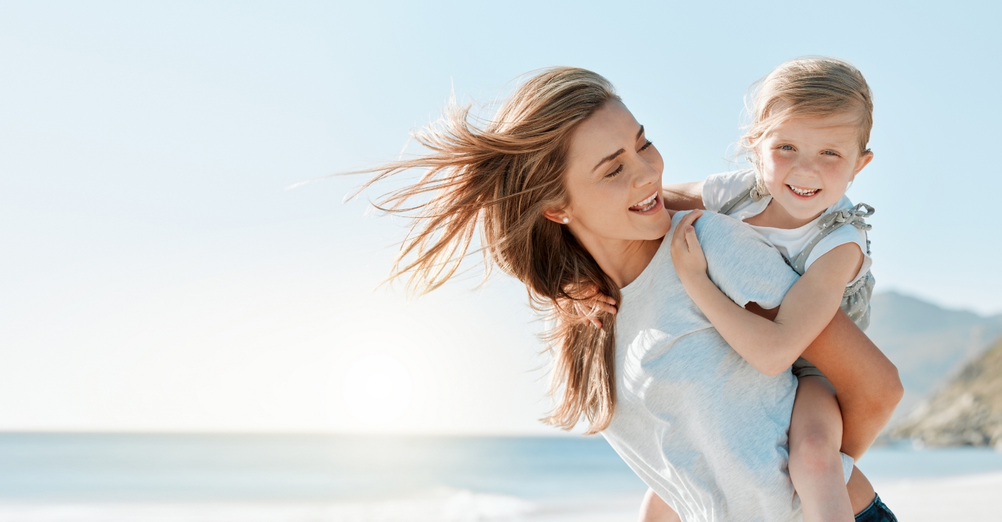 Mom carrying young daughter on back