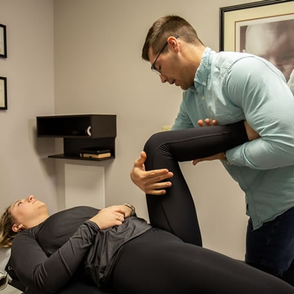 Dr. Jon Mudlaff adjusting a patient's leg.