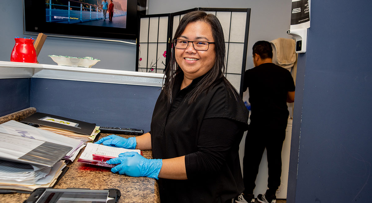 Staff smiling behind desk