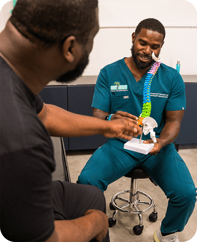 Dr. Randall Thompson showing a 3d model of a spine to a patient.