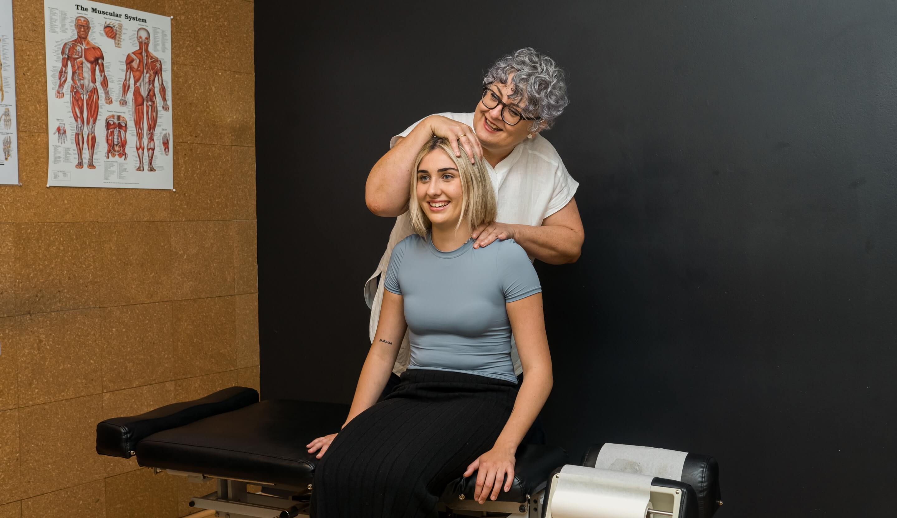 A woman sitting and receiving a neck adjustment.