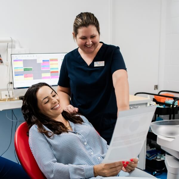Hervey Bay Dental team handing patient paperwork