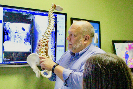 Dr. Steve Niemiec educating patient with model of spine