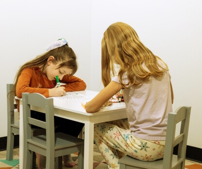 Two girls drawing in a children's play area