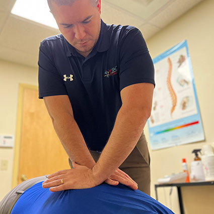 chiropractor adjusting patients back