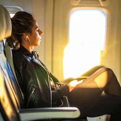 woman sitting at the window seat on a plane