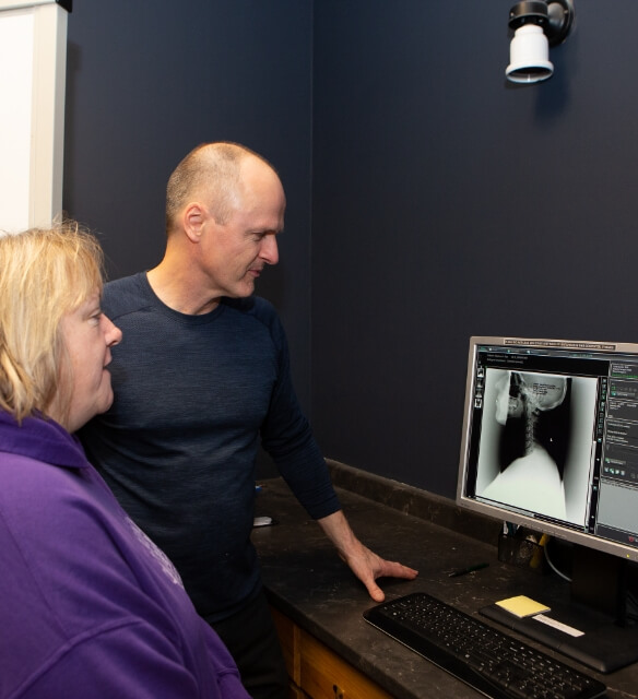 Dr. Tim showing x-rays to a patient