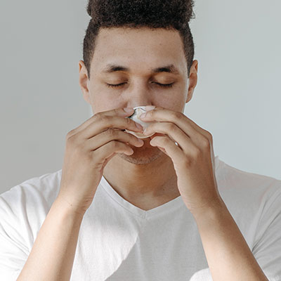 person sneezing into tissue