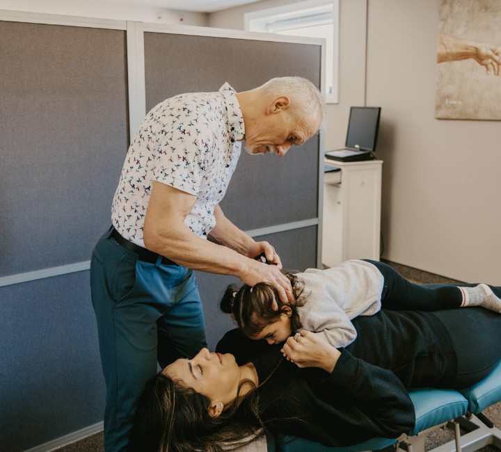 Chiropractor with mother and child patient