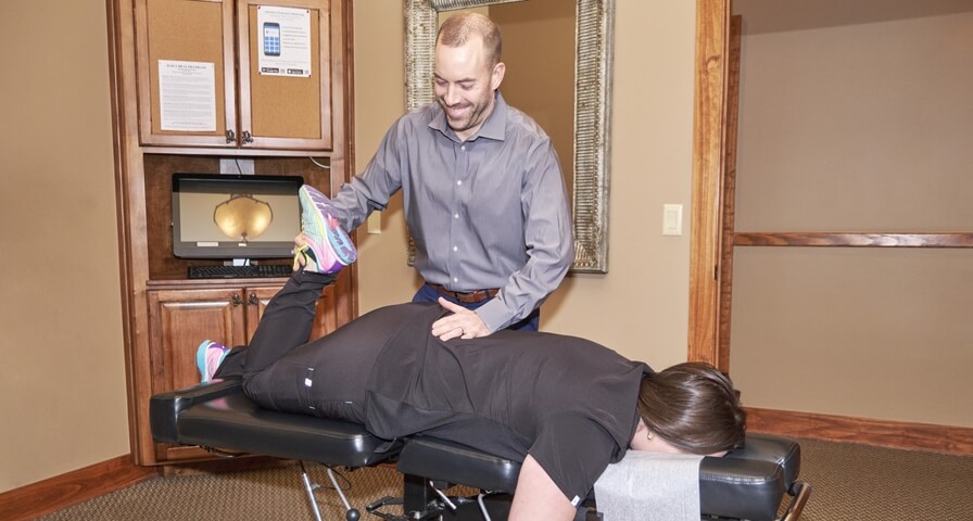 patient having leg adjusted by chiropractor
