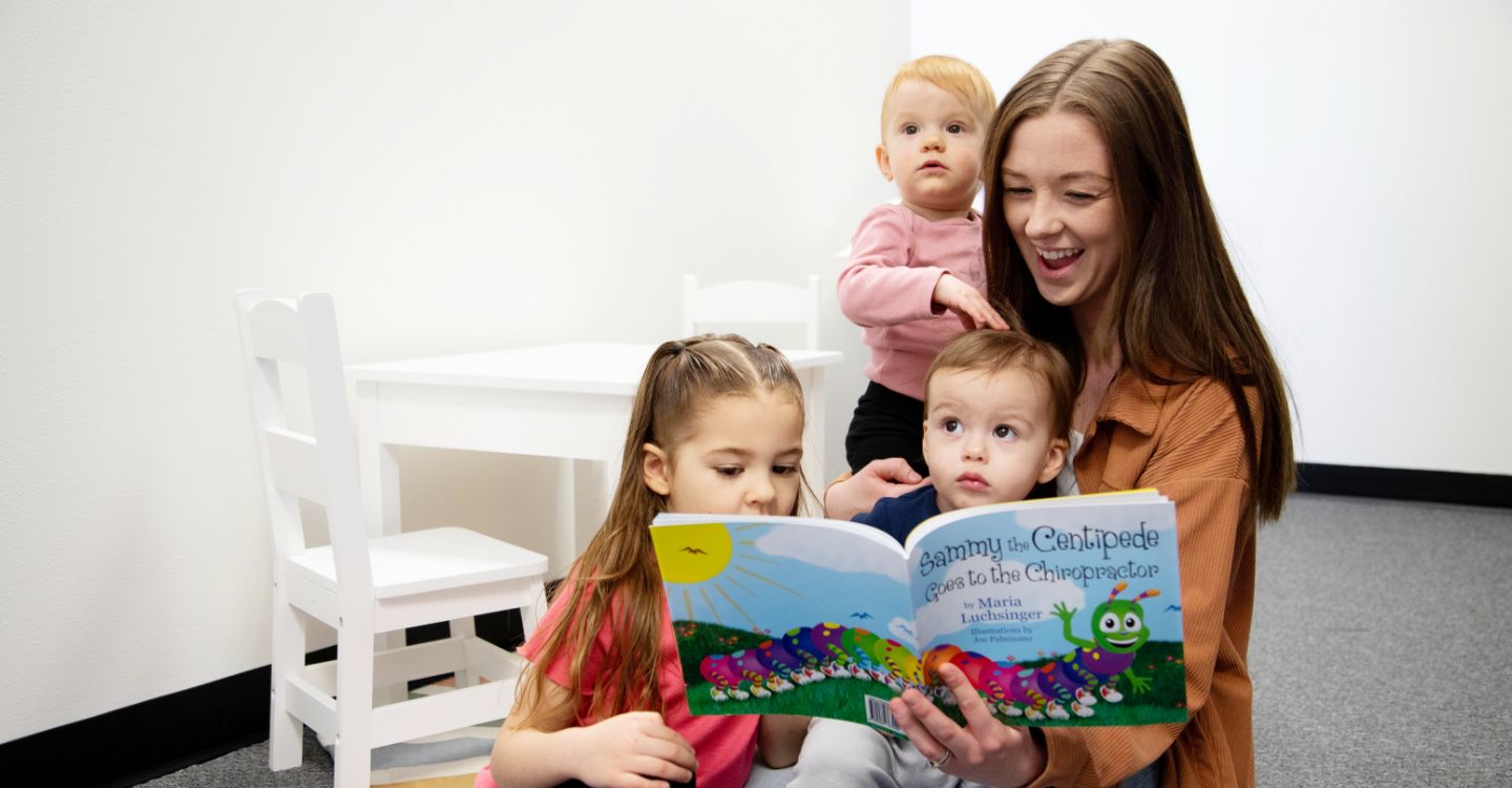 Woman reading books with kids 