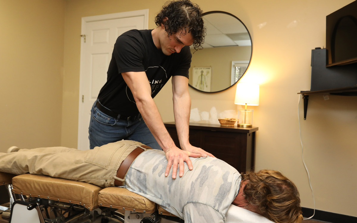 Dr. Daron adjusting a patient on a chiropractic table