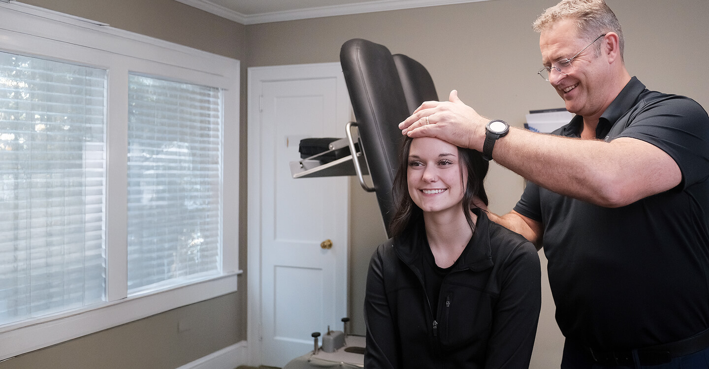 Lawrenceville chiropractor Dr Chris adjusting patients neck