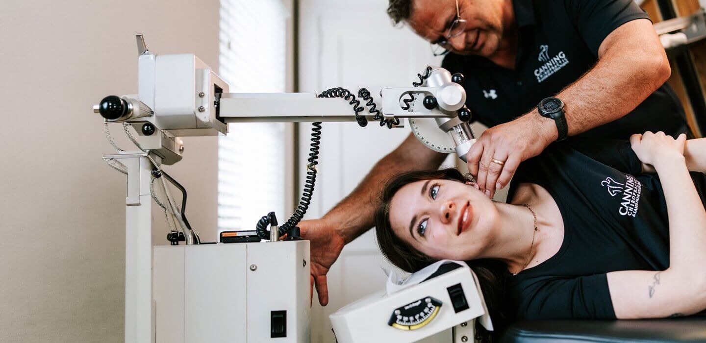 Lawrenceville chiropractor Dr Chris using tool to adjust patients back