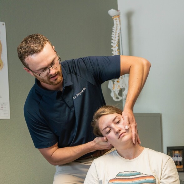 doctor adjusting patient's neck