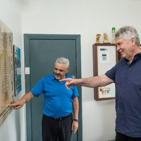 Chiropractor and patient pointing at chart