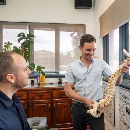 Chiropractor holding spine model