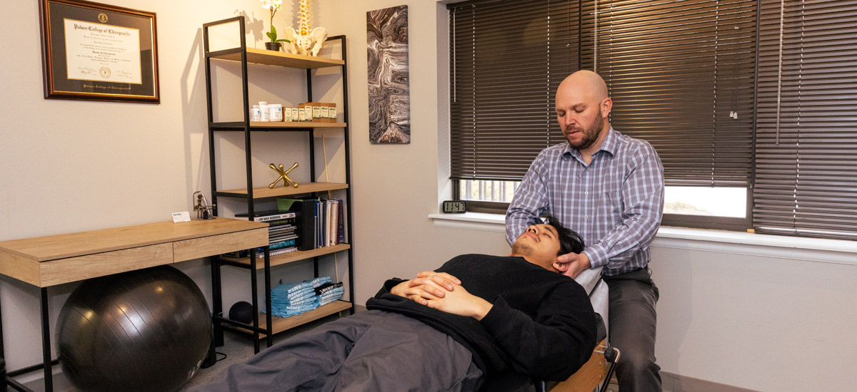Dr. Ryan Ronnebaum adjusting a client's neck