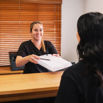 Handing paperwork to patient