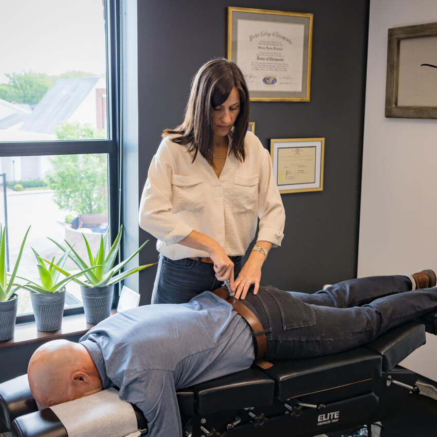 Dr Stacey adjusting patients back using a tool