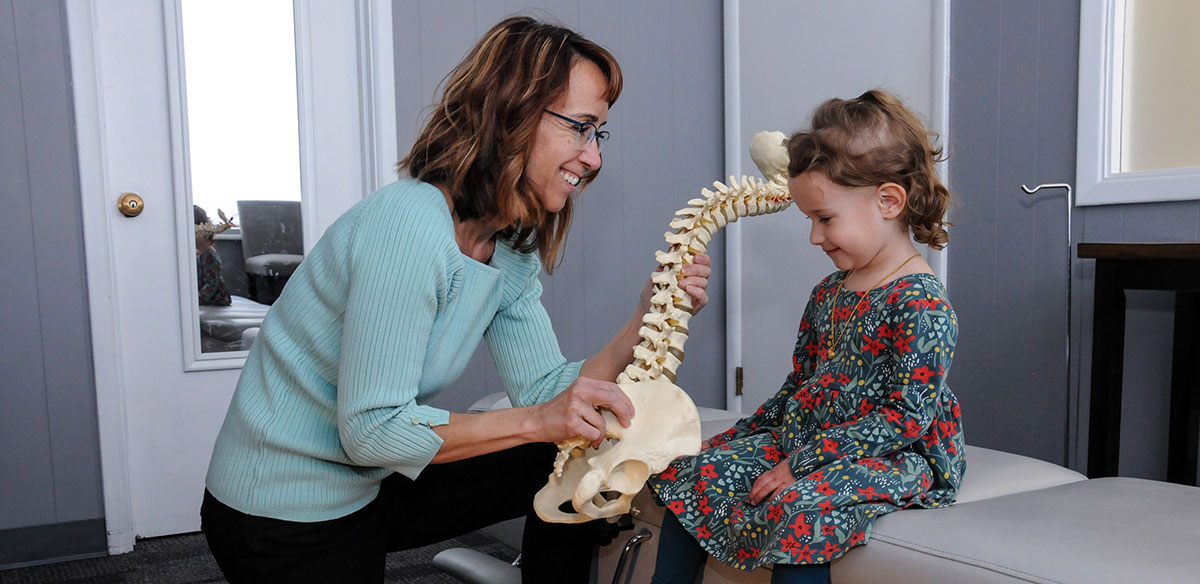 Showing spine model to young girl
