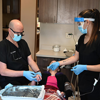 Dental hygienist handing dentist tools