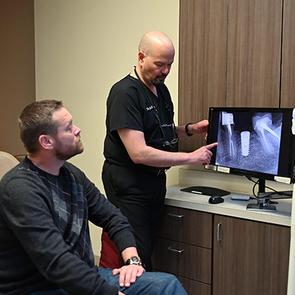 patient and dentist looking at xray