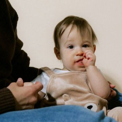 A mother holding her baby on her lap.