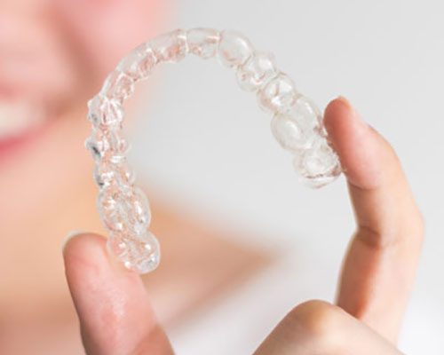 person holding clear aligner