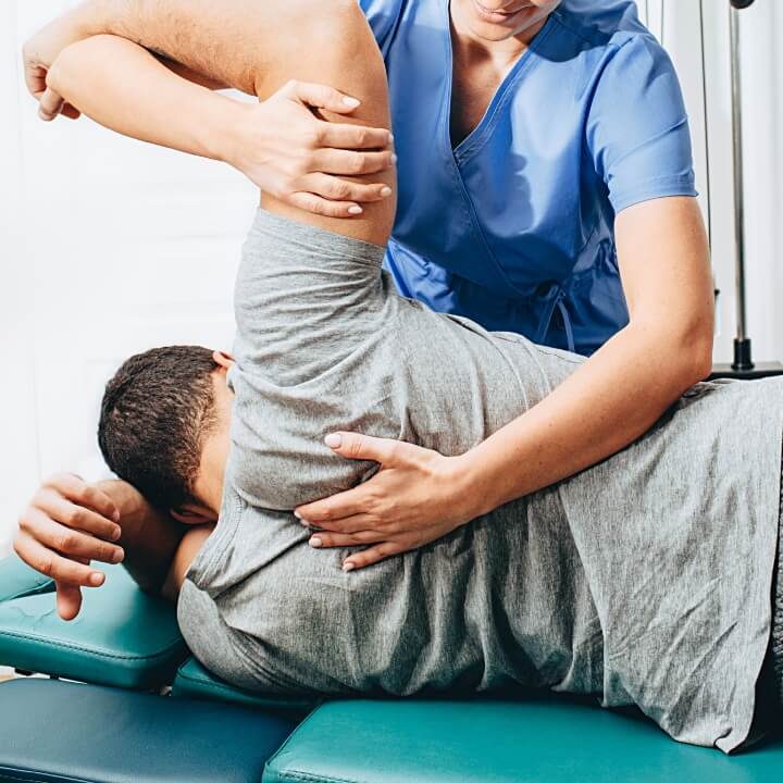 chiropractor adjusting persons shoulder