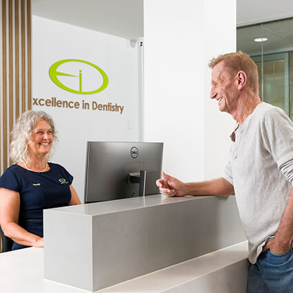 Patient checking in at Excellence in Dentistry front desk