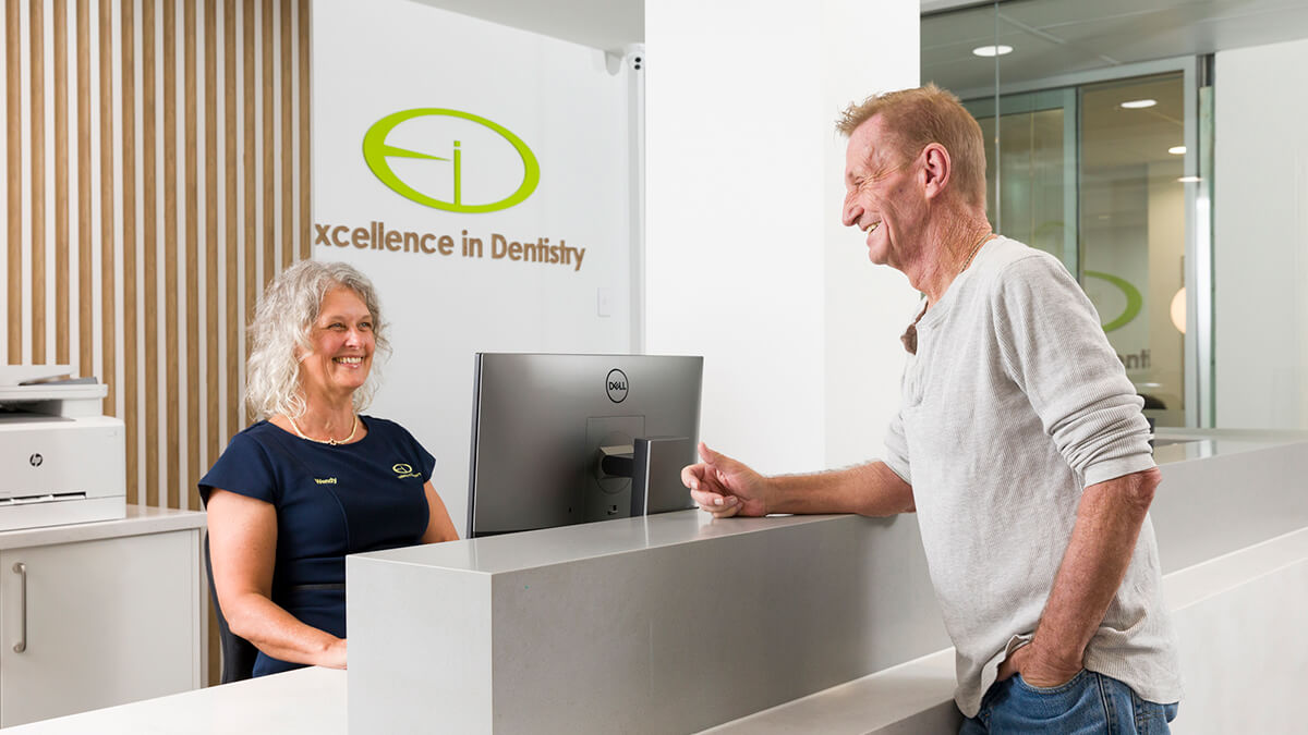 Patient checking in at Excellence in Dentistry front desk