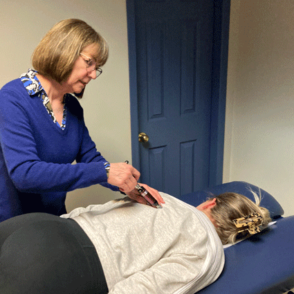 Woman being adjusted using an instrument