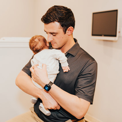Dr. Zac Pinter holding a baby