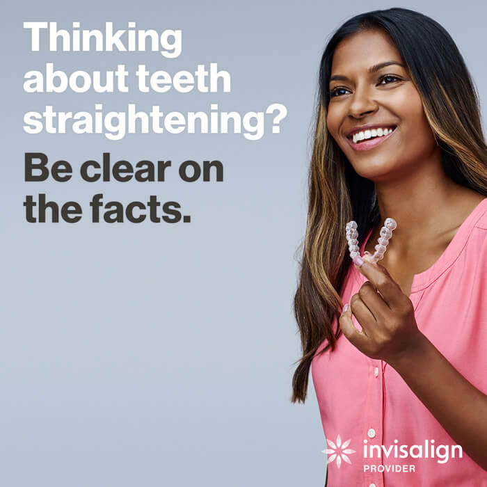 woman holding invisalign aligner smiling