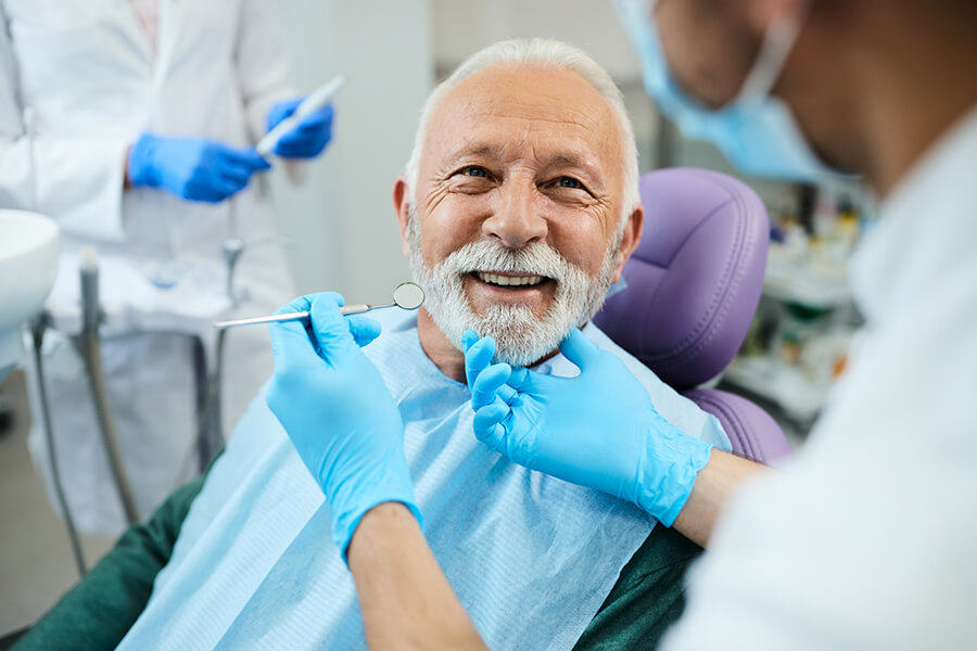 Smiling elderly man in dental chair
