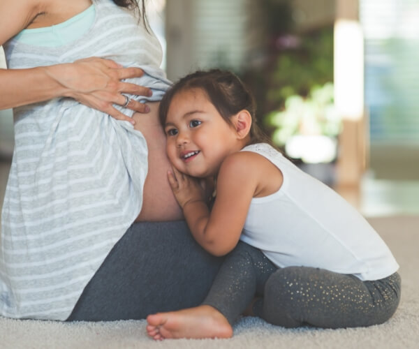 daughter holding pregnant mom tummy