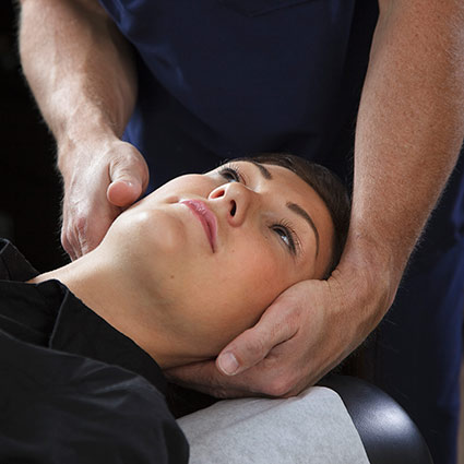 chiropractor adjusting persons neck