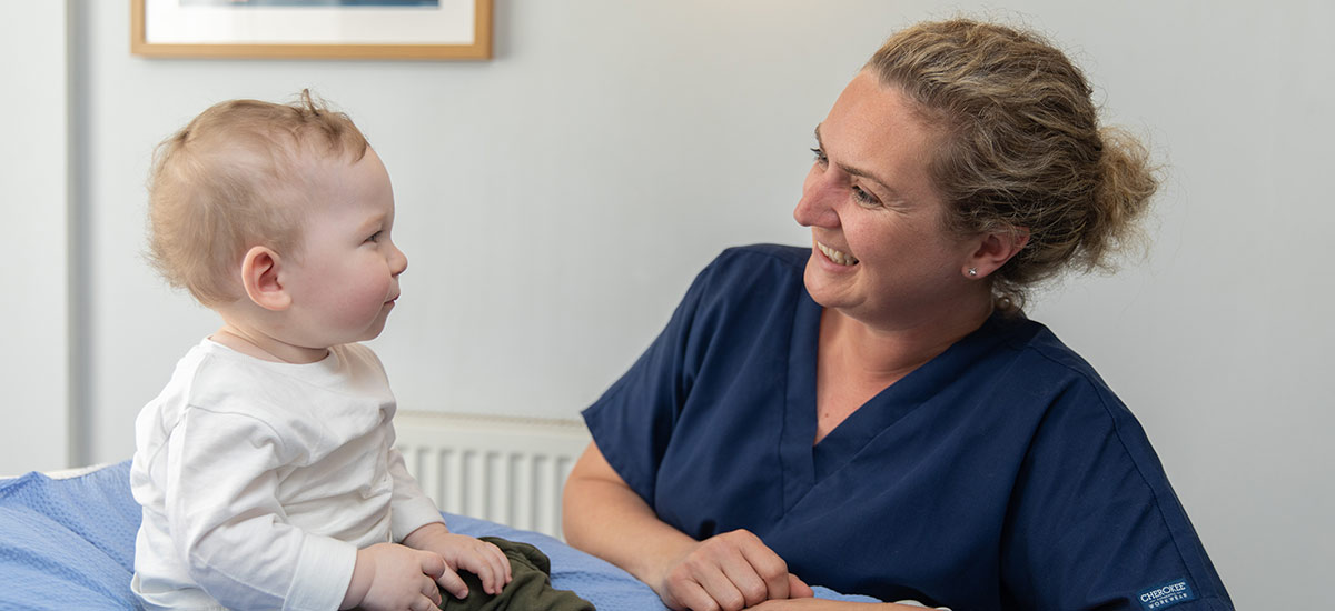 chiropractor smiling at baby