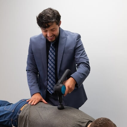 Dr Jose using tool on patients back