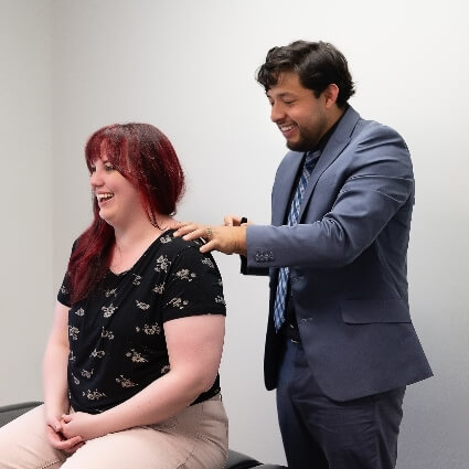 Dr Jose adjusting patients shoulders