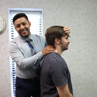 Dr Jose smiling adjusting patients neck