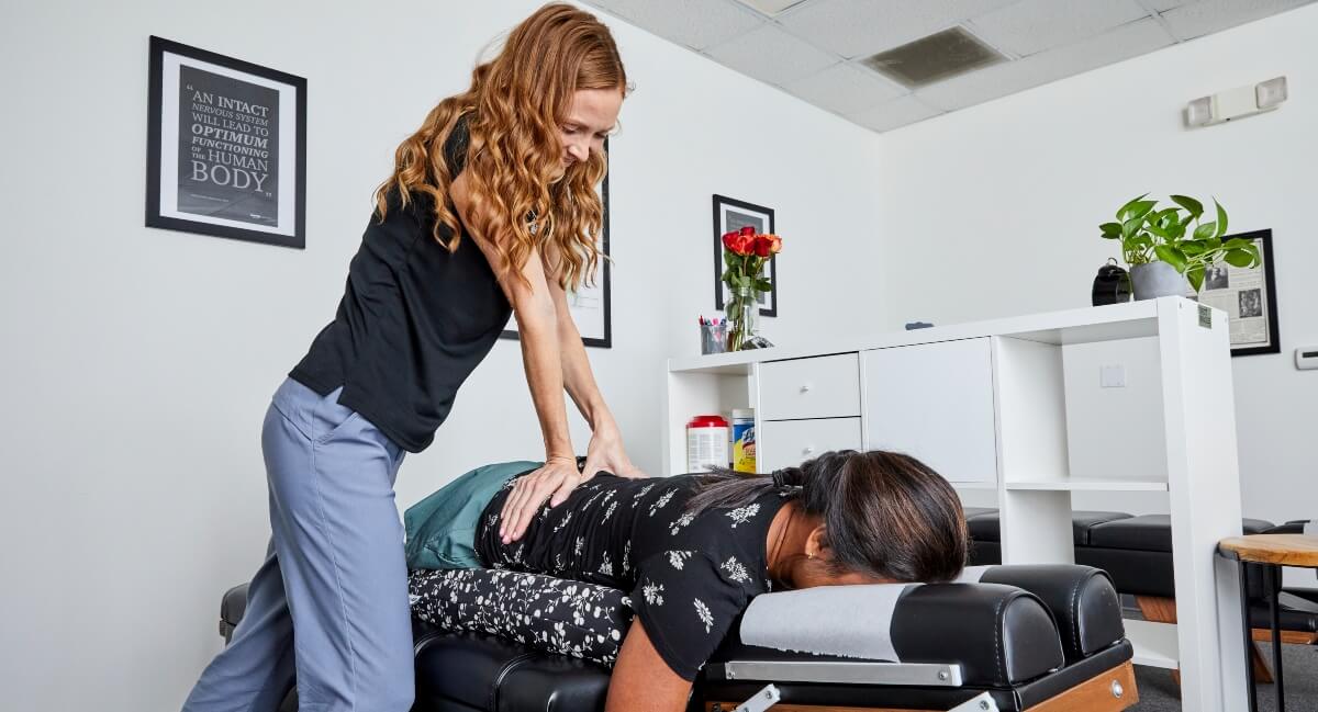 Dr. Victoria of Awaken Chiropractic Center attending to pregnant patient