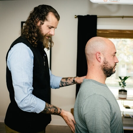 Chiropractor adjusting patient's upper-back