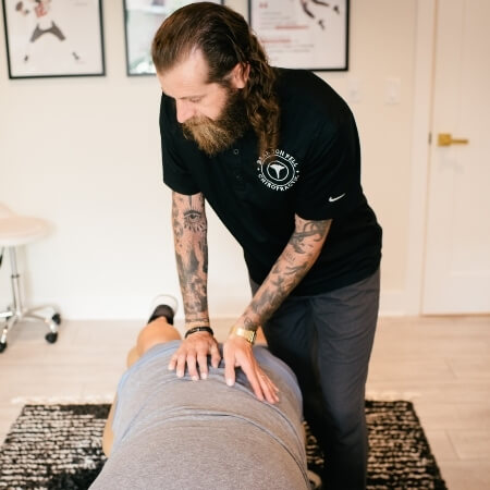 Chiropractor adjusting a male patient's back